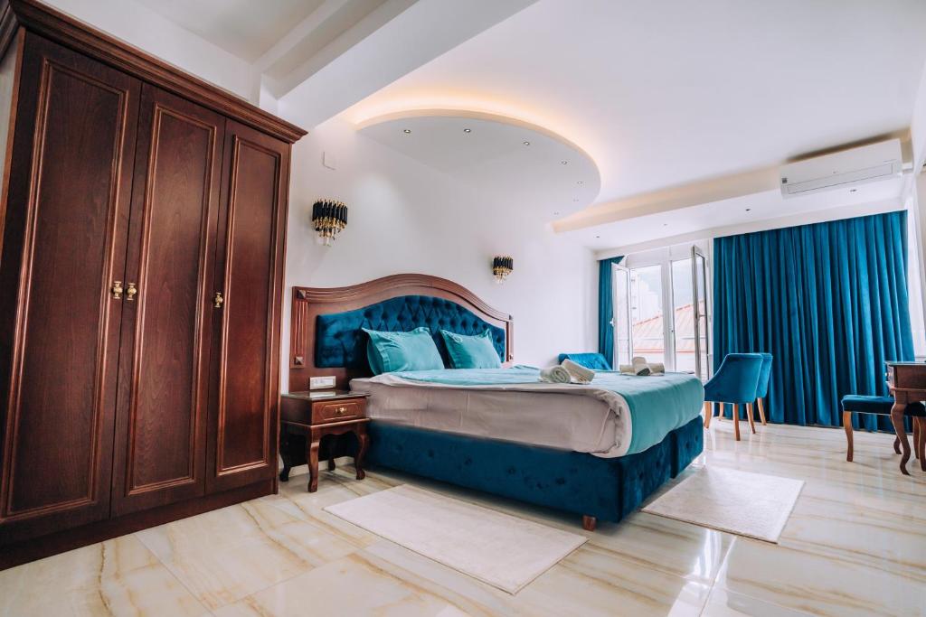 una camera con letto blu e tavolo e sedie di Villa Afrodita City Center a Ohrid