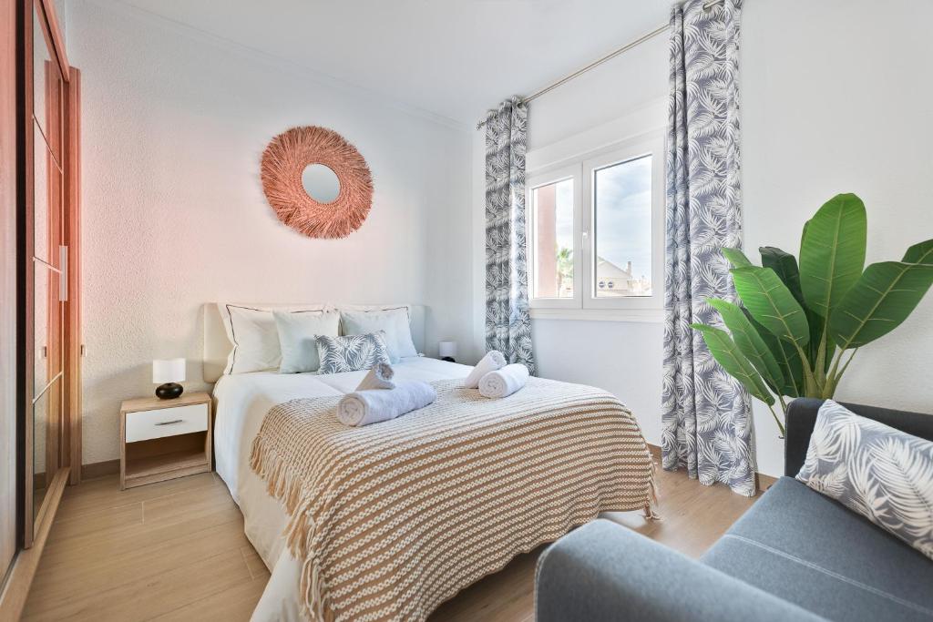 ein Schlafzimmer mit einem Bett mit Handtüchern darauf in der Unterkunft Apartamento ESTRELLA con vistas a la piscina in Torrevieja