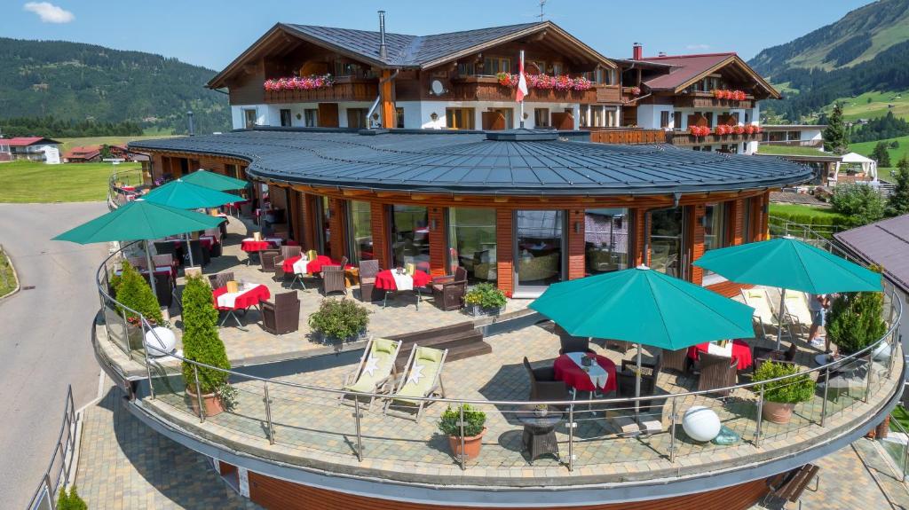 an aerial view of a building with chairs and umbrellas at Hotel Birkenhöhe in Hirschegg