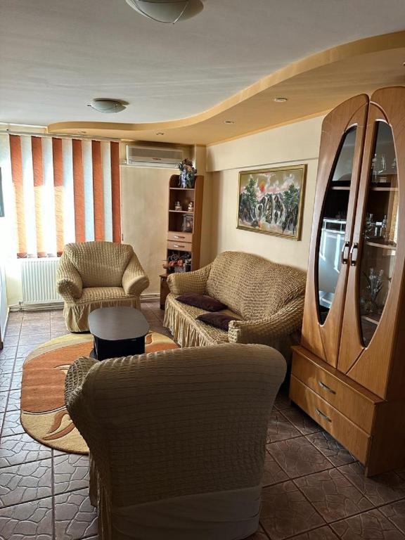 un soggiorno con divano, sedie e TV di Apartament CASA ALEXIA a Botoşani