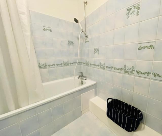 biała łazienka z wanną i umywalką w obiekcie Appartement Petit Messier w mieście Senones