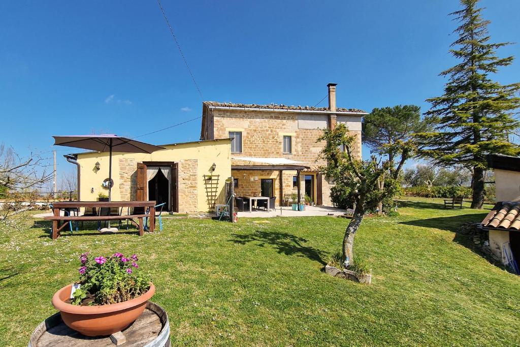 ein Steinhaus mit einem Tisch und Blumen im Hof in der Unterkunft Villa Pilotti Country House in Penna San Giovanni