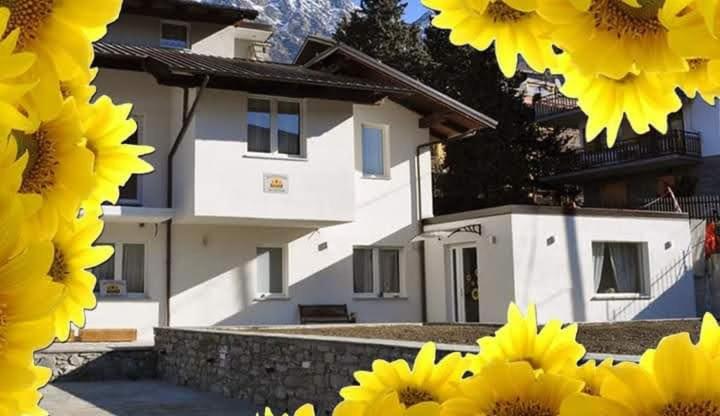 a house with yellow sunflowers in front of it at Il Girasole in Saint Vincent