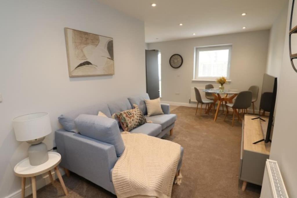 sala de estar con sofá azul y mesa en The Hive - IH21ALL - APT 2, en Thornaby on Tees