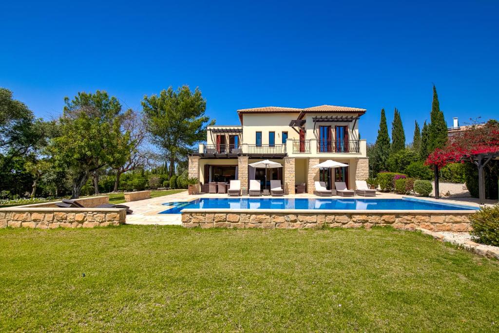 4 bedroom Villa Galinios with large private pool, Aphrodite Hills Resort في كوكليا: منزل فيه مسبح في ساحة