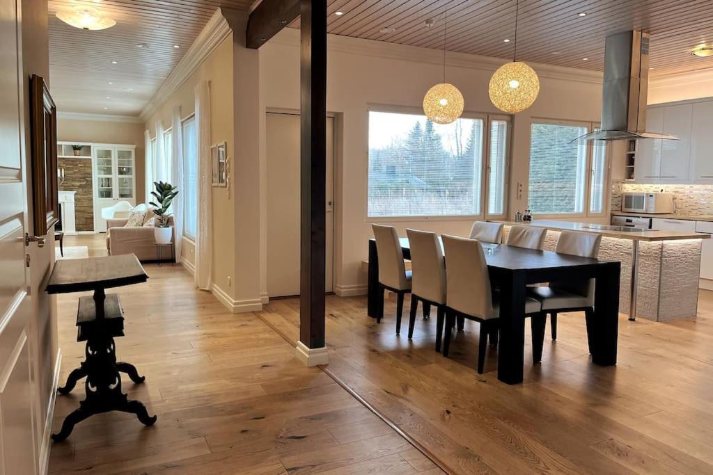 a dining room and kitchen with a table and chairs at Stunning 5BR 16 Bed Home with Finnish Sauna & Jacuzzi 340 m2 in Tampere
