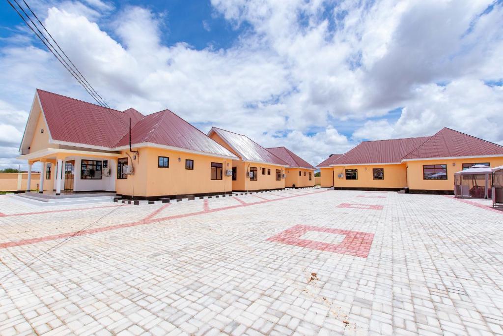 une rangée de bâtiments avec des toits rouges sur une cour dans l'établissement Dodoma Shine Lodge, à Dodoma