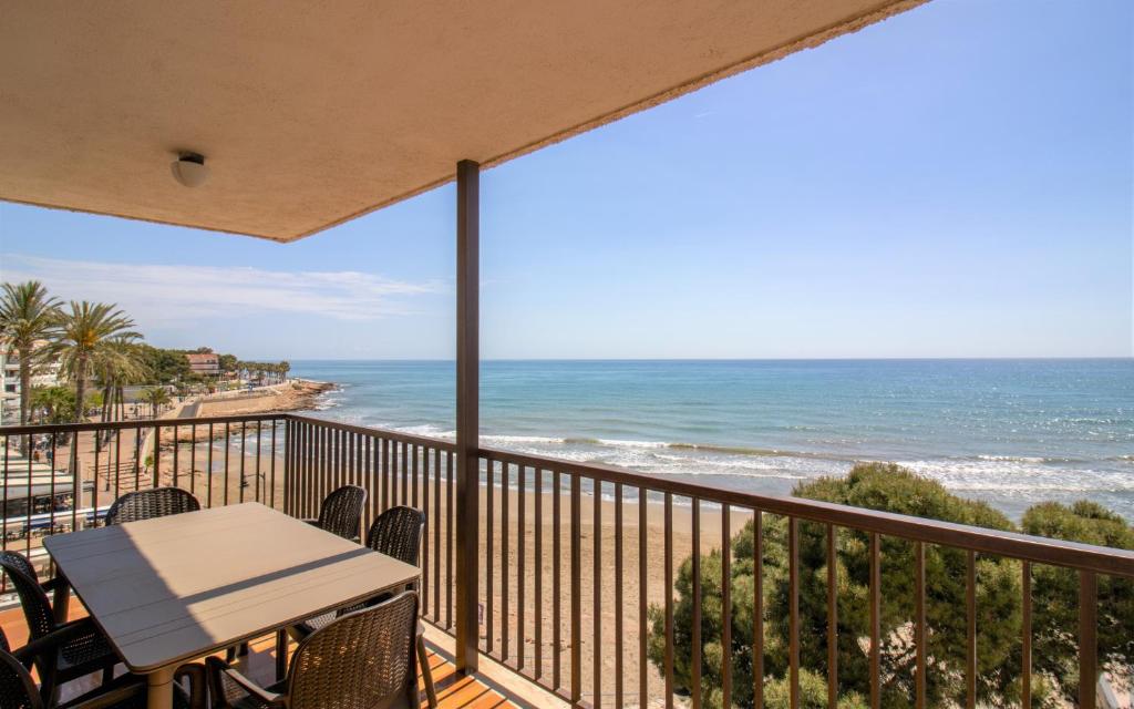 a balcony with a table and chairs and the ocean at Apartamento con vistas frontales - Primera línea Playa Cargador - ALBERT VILLAS in Alcossebre