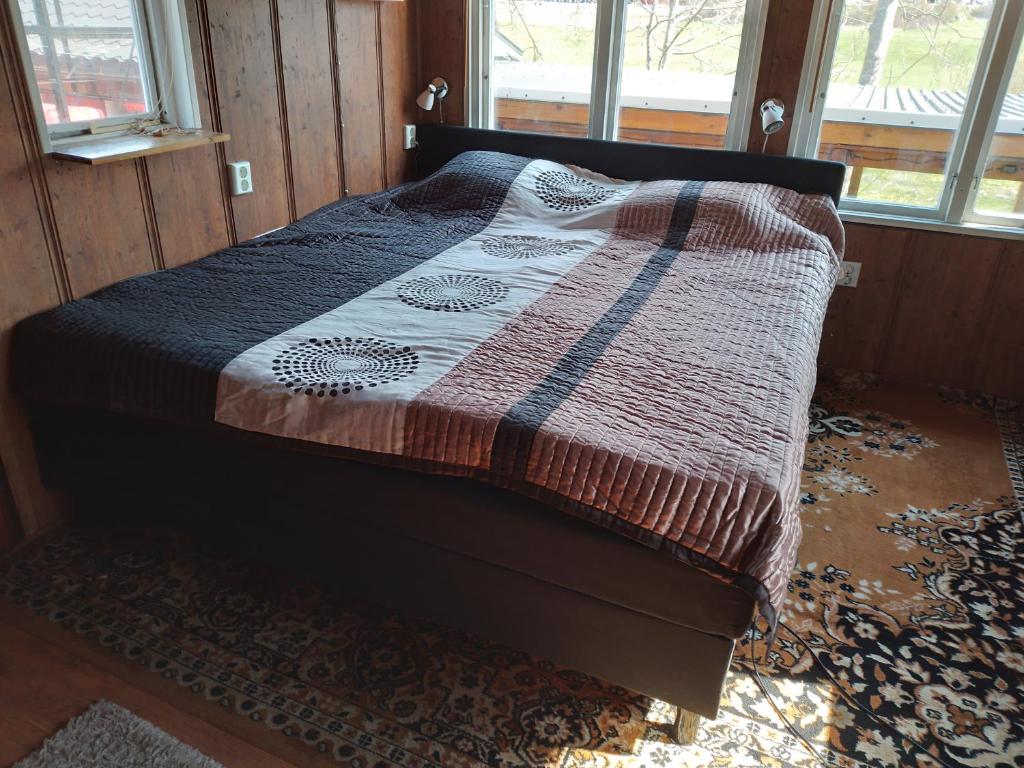 uma cama com um cobertor num quarto em Tegelvägen B em Nättrabyhamn