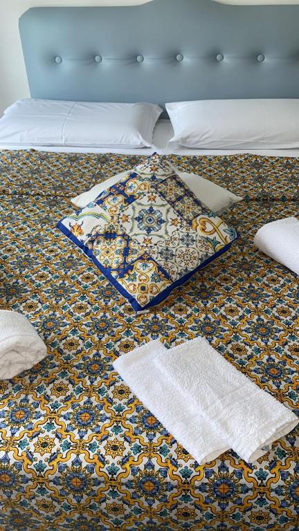 a bed with a blanket and pillows on it at Alba central City in Palermo