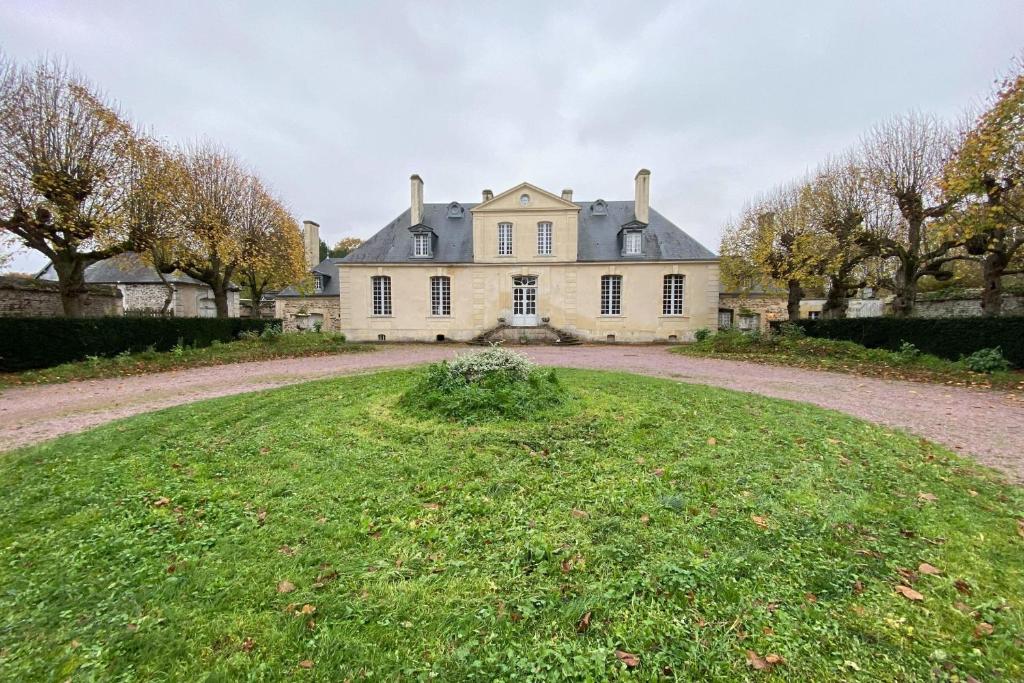 une grande maison avec une grande pelouse devant elle dans l'établissement Large castle with garden near Caen, 