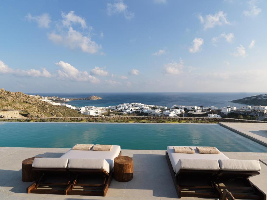 basen z 2 leżakami i widokiem na ocean w obiekcie Ezio Bo Luxury Living w mieście Mykonos