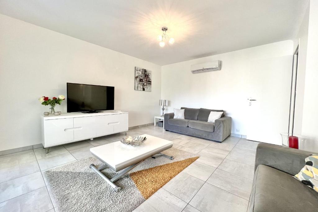 un salon avec une télévision et un canapé dans l'établissement Beautiful T2 large terrace near Center & sea, à Cannes