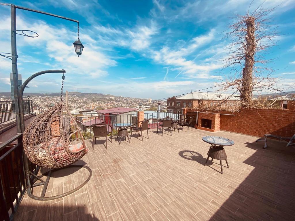 um pátio com cadeiras e um baloiço numa varanda em 9 Borbalo Street Apartment with terrace em Tbilisi