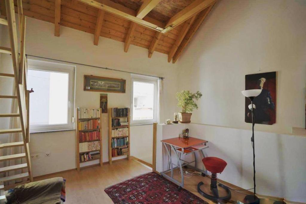 uma sala de estar com uma mesa e uma estante de livros em Studio im Bezirk Lend em Graz
