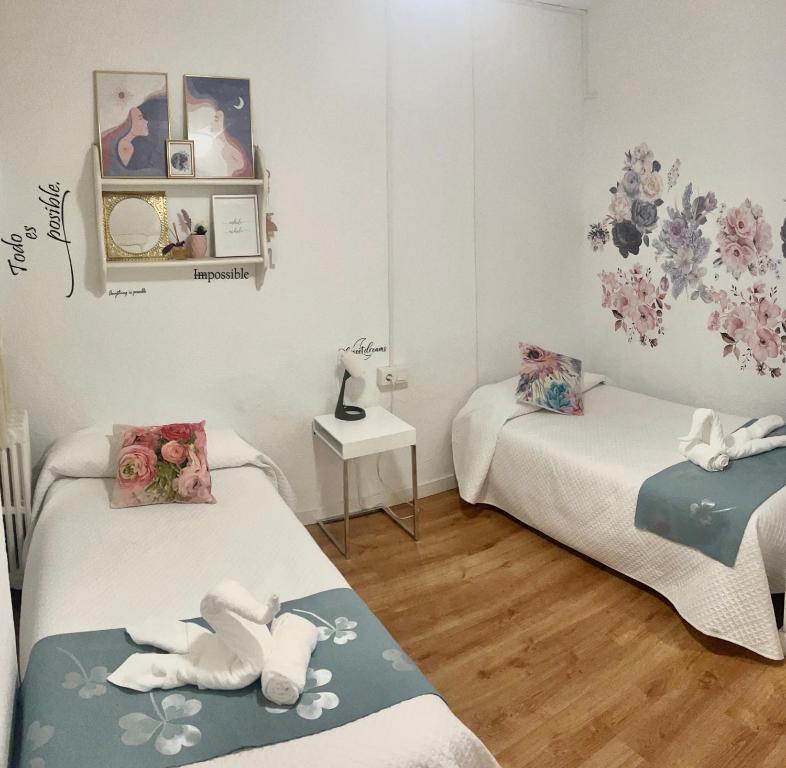 a room with two beds and a table at Luna Centro 5 habitaciones in Granada