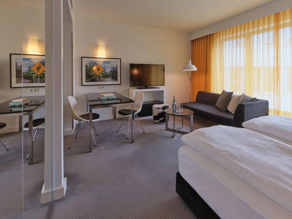 a hotel room with a bed and a living room at Adina Apartment Hotel Berlin Hackescher Markt in Berlin