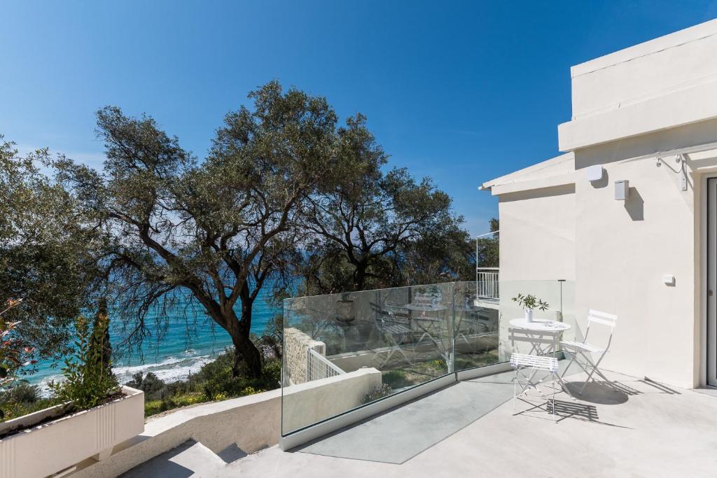 a white house with a balcony with a view of the ocean at Villa Rustica in Agios Gordios