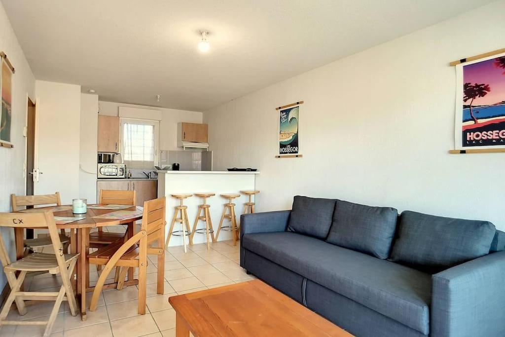 ein Wohnzimmer mit Couch und Tisch und eine Küche in der Unterkunft V-Mimosas 01-Vieux Boucau Appartement 6 personnes calme au cœur de Vieux Boucau proche skatepark in Vieux-Boucau-les-Bains