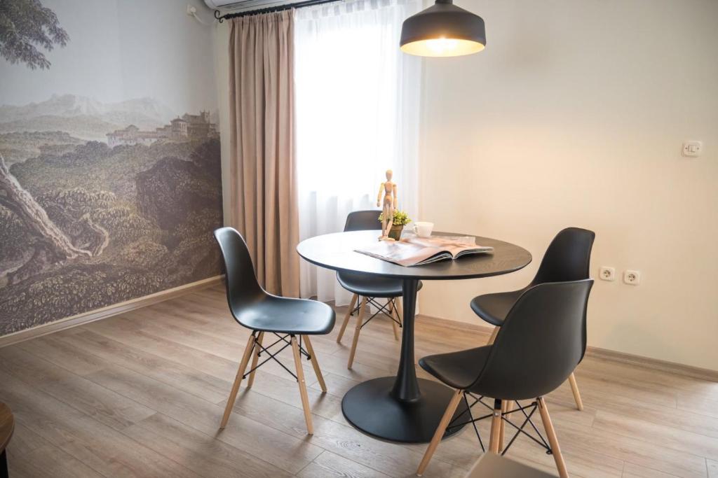 - une salle à manger avec une table et quatre chaises dans l'établissement BEST APARTMENTS, à Bitola