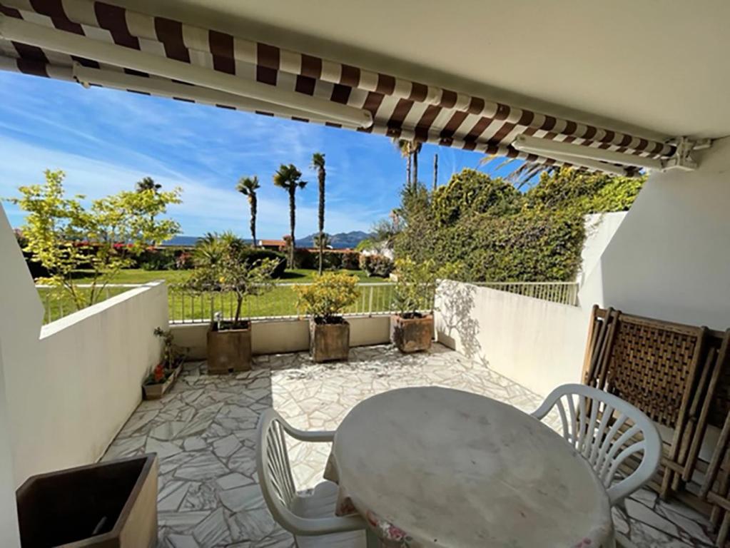 patio ze stołem, krzesłami i ogrodzeniem w obiekcie PAN0 - Studio avec belle et grande terrasse vue mer w Cannes