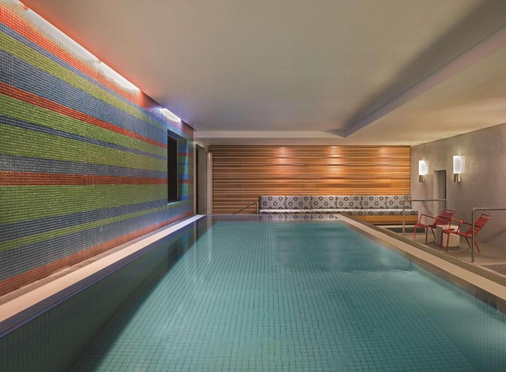 Adina Apartment Hotel Berlin Mitte في برلين: حمام سباحة في منزل به جدار ملون