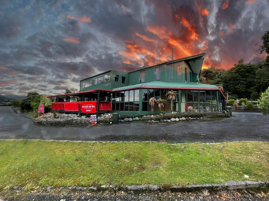Ein Gebäude mit einem roten und grünen Zug. in der Unterkunft Fox Glacier Jade Hotel in Fox Glacier