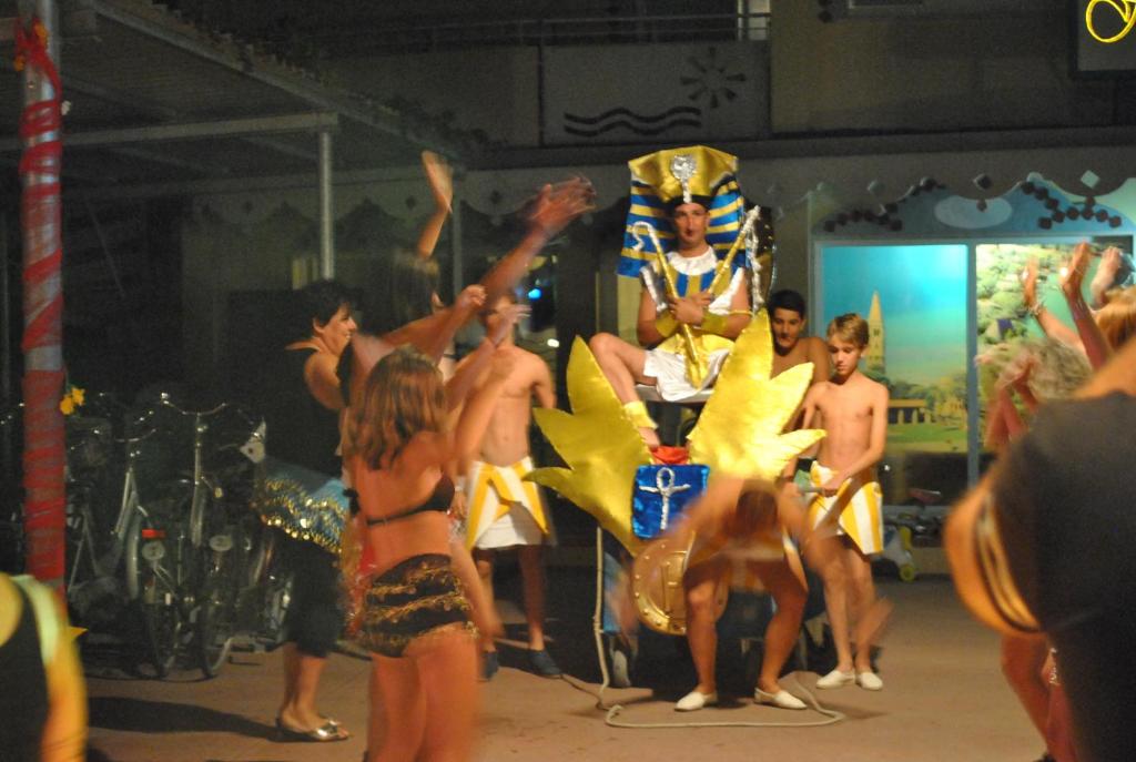 a group of people in bathing suits standing around a performance at Hotel Maxim in Caorle