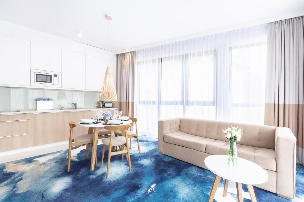 a living room with a couch and a table at VacationClub - Boulevard Residence Apartament 11 in Ustronie Morskie