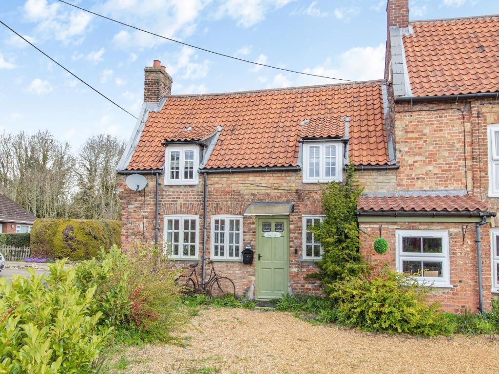 an old brick house with a green door at The Innkeep in Watlington