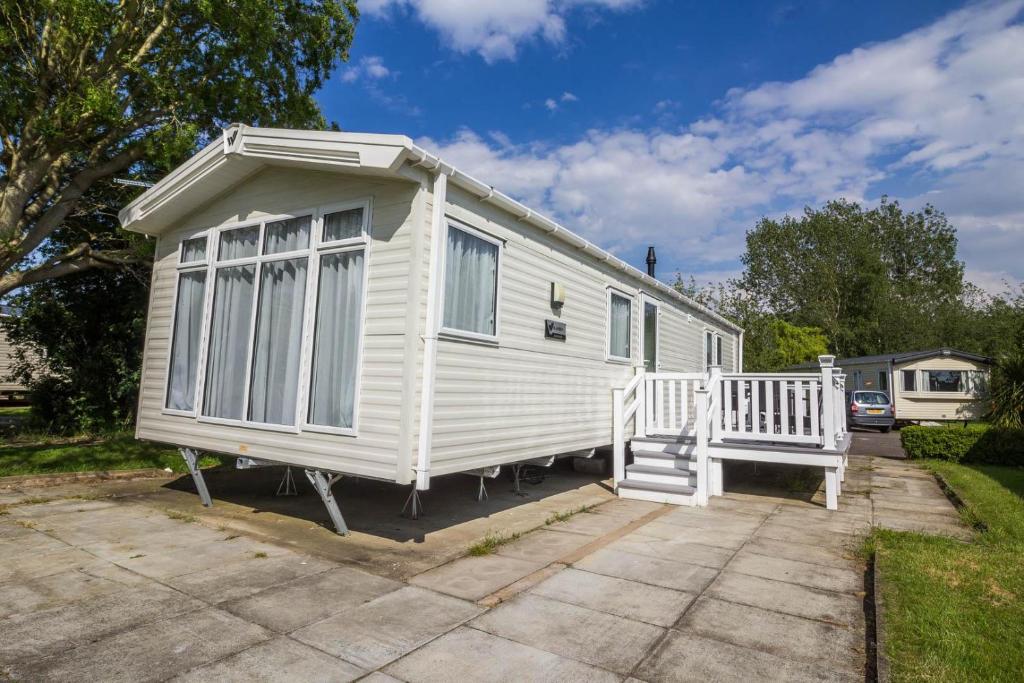 une petite maison blanche assise dans une allée dans l'établissement Great Caravan With Decking Southview Holiday Park In Skegness Ref 33002v, à Skegness