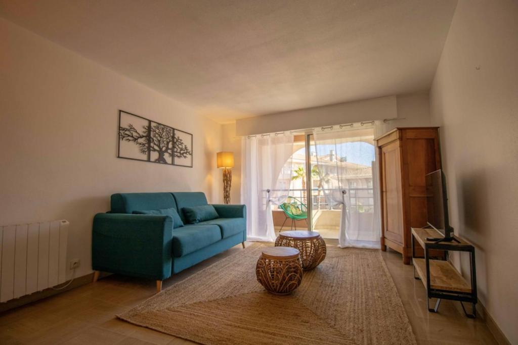 ein Wohnzimmer mit einem blauen Sofa und einem TV in der Unterkunft Nice quiet nest near Fréjus Plage and Port Fréjus in Fréjus