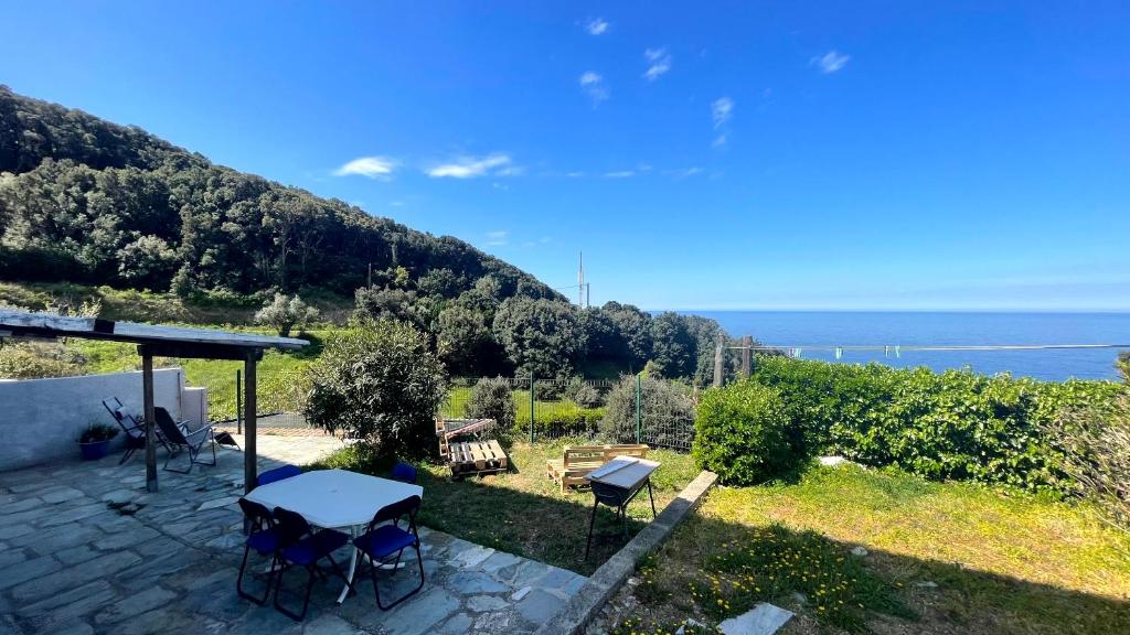 un patio con mesas y vistas al océano en MER & SOLEIL en Morsiglia