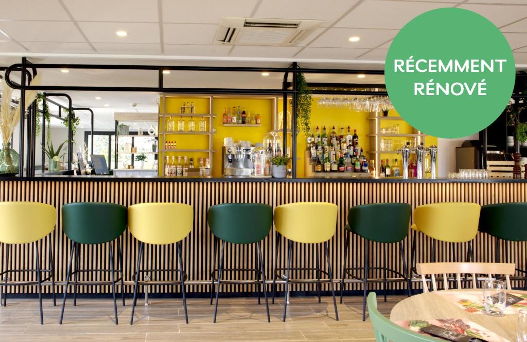 une rangée de chaises jaunes et vertes dans un restaurant dans l'établissement Campanile Limoges Nord, à Limoges