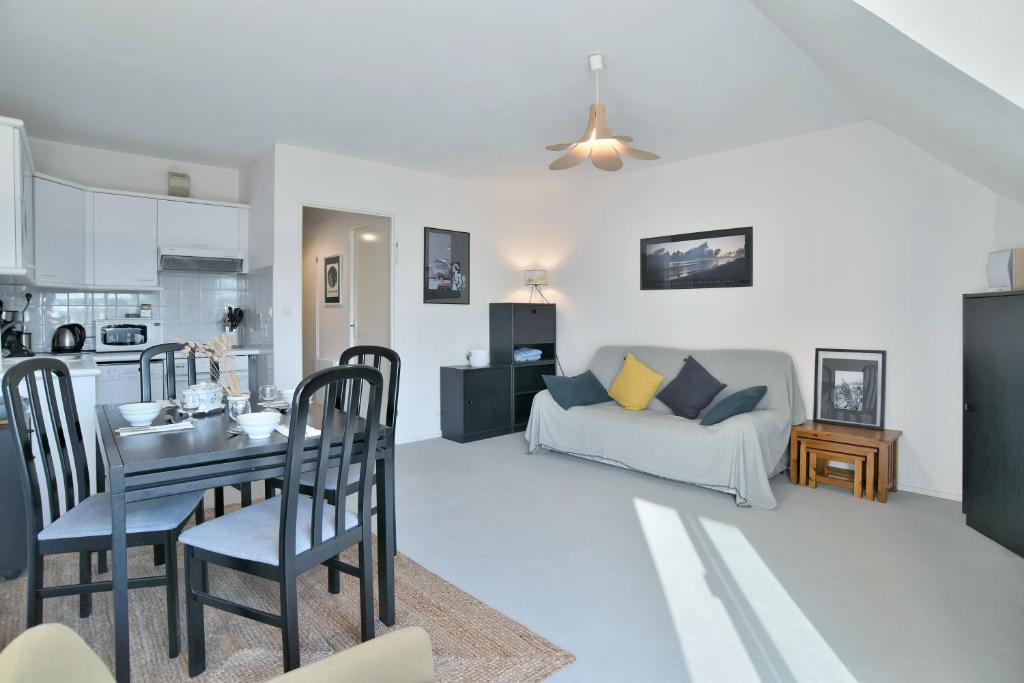 un salon avec une table et un canapé dans l'établissement Le Jean Bart - À 20m de la plage, à Saint-Cast-le-Guildo