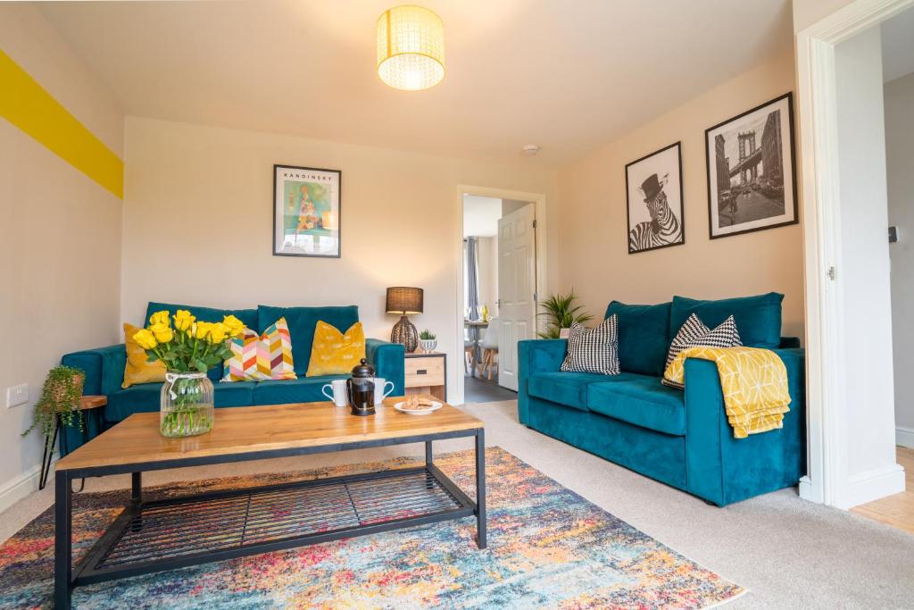 a living room with blue couches and a coffee table at Saltbox Stays - 3 Bed with off-street parking, fast Wifi, sleeps 7, Central location in Ashby de la Zouch
