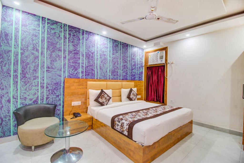 a bedroom with a bed and a desk and a chair at FabHotel Gross Inn Suites in New Delhi