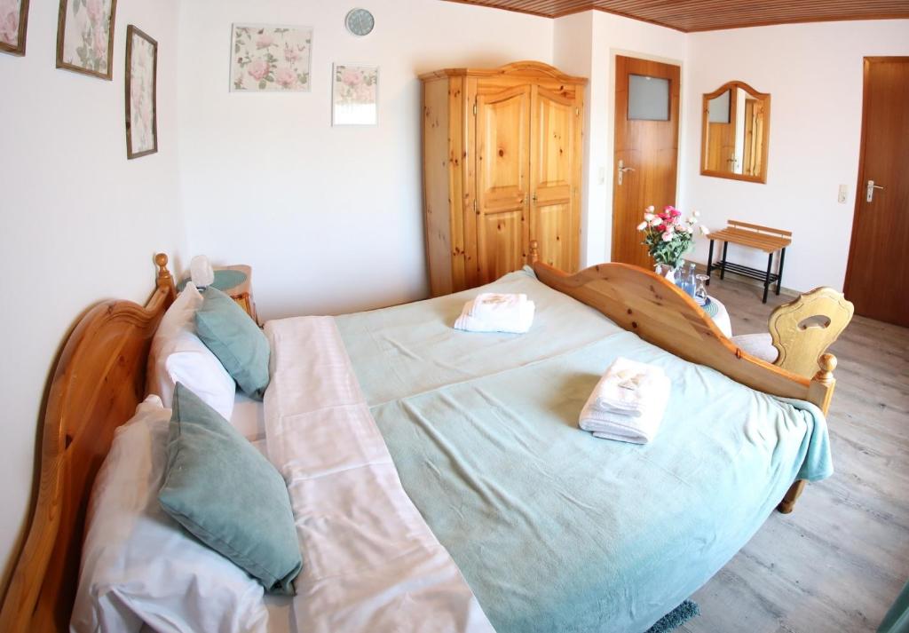a bedroom with a large wooden bed with blue pillows at Zum Burgkeller in Bruchweiler