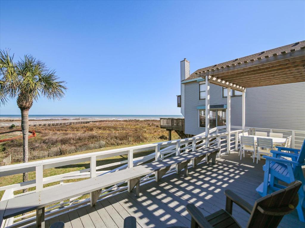 a deck with benches and tables on the beach at La Dolce Vita Playa San Luis in Galveston