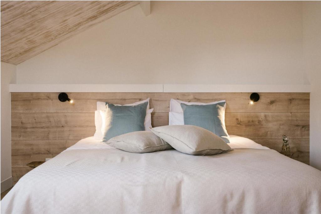 a bedroom with a white bed with pillows at Brut the lodges in Reijmerstok