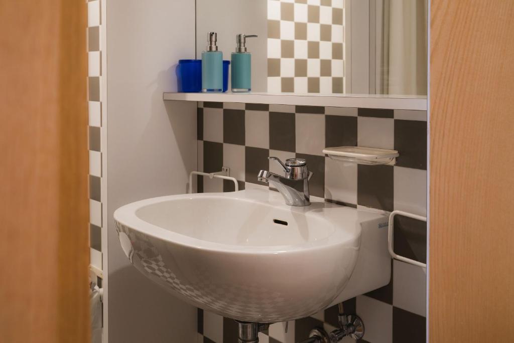 a bathroom with a white sink and a mirror at Mandron charming and central apartment in Madonna di Campiglio