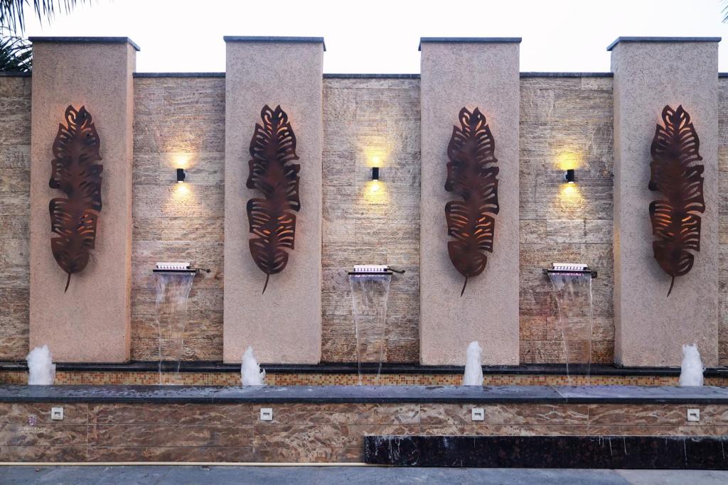 a brick wall with peacock feather sculptures on it at Pride Hotel Bhopal in Bhopal