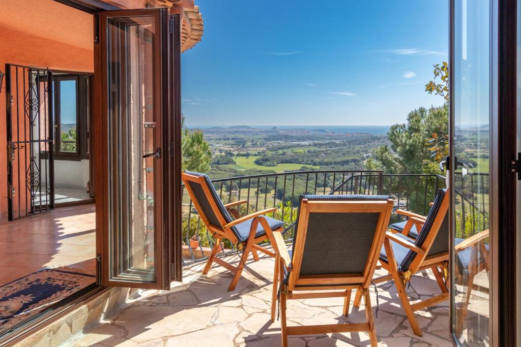 a patio with chairs and a table on a balcony at Villa Bonaventura in Calonge