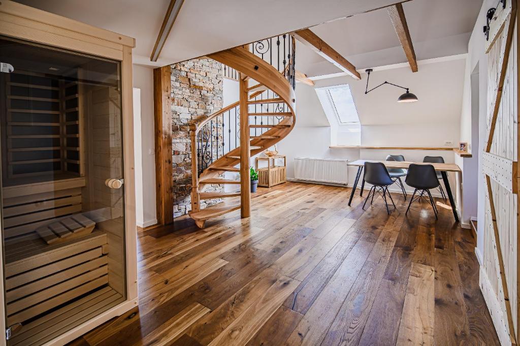 Habitación con escalera, mesa y sillas en Mountain View Apartment with Sauna, en Cerklje na Gorenjskem