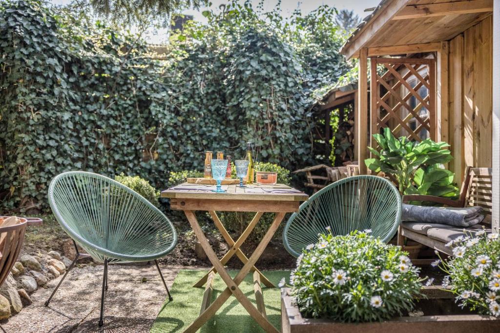 een patio met 2 stoelen en een tafel in de tuin bij Modernes Landapartment in Seevetal