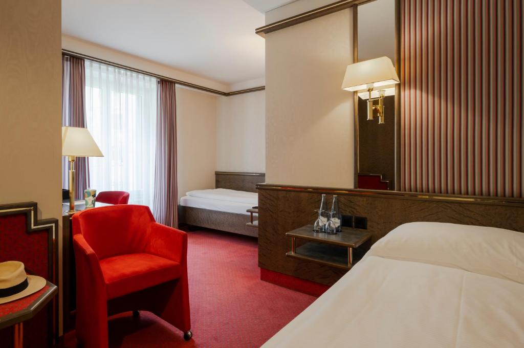 Uma cama ou camas num quarto em Hotel Monopol Luzern