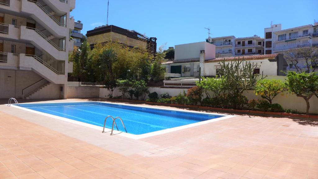 a swimming pool in front of a building at Apartamentos Decathlon in Salou