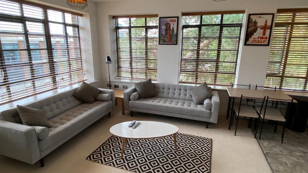 a living room with two couches and a table at Wallis Square in Farnborough