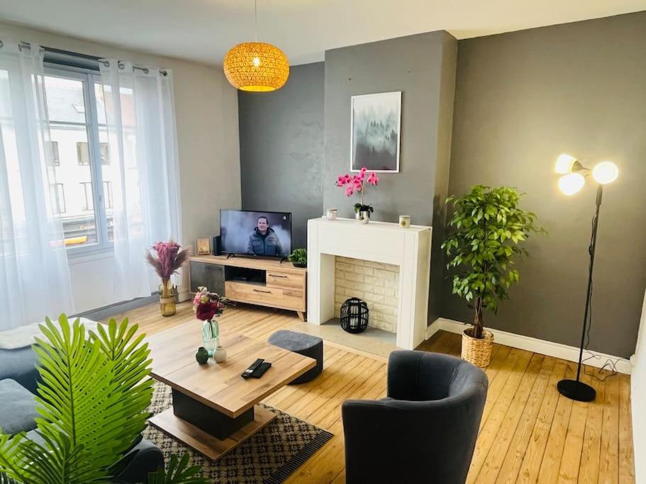 een woonkamer met een tafel en een tv. bij « Bel’ Epoque » proche vieille ville 6 pers, WIFI in Boulogne-sur-Mer