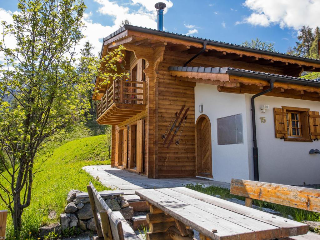 a log cabin with a wooden bench in front of it at Chalet Colonia in La Tzoumaz